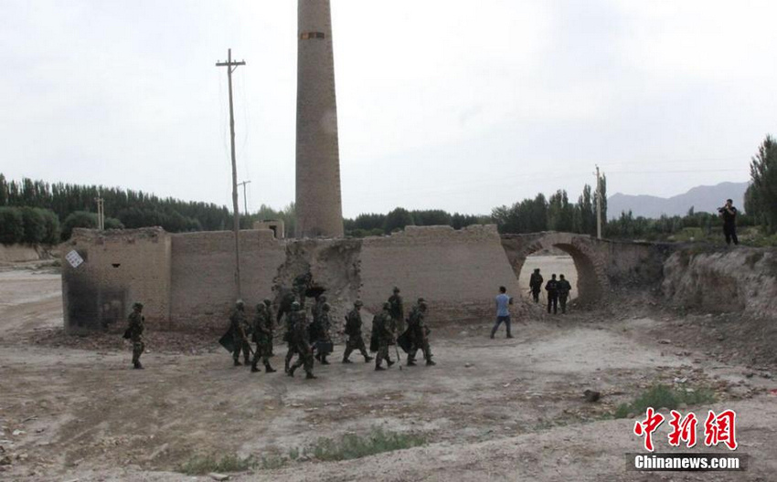 图为8月10日民兵及武警特警在一处废弃的砖厂搜捕逃逸暴徒。