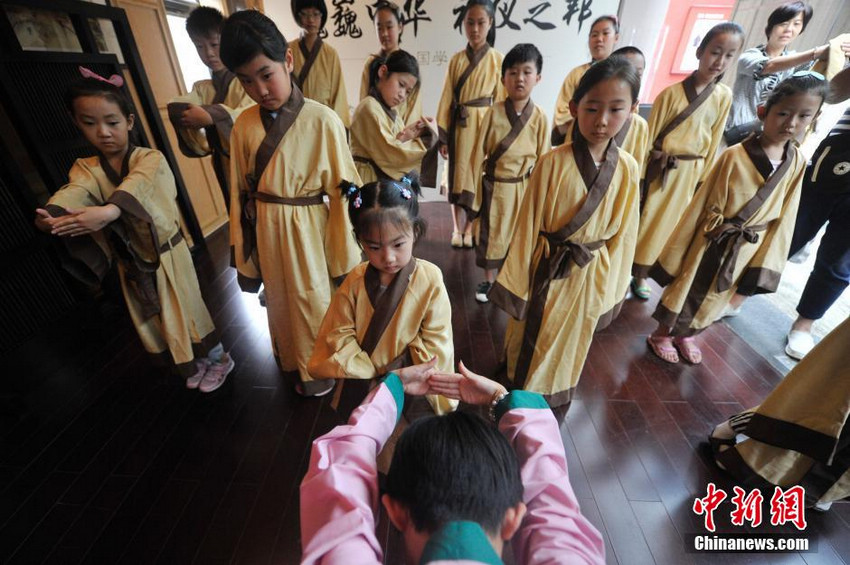 图为少年儿童学习古代男子的传统礼仪。