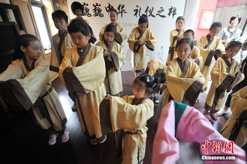 图为少年儿童学习古代男子的传统礼仪。