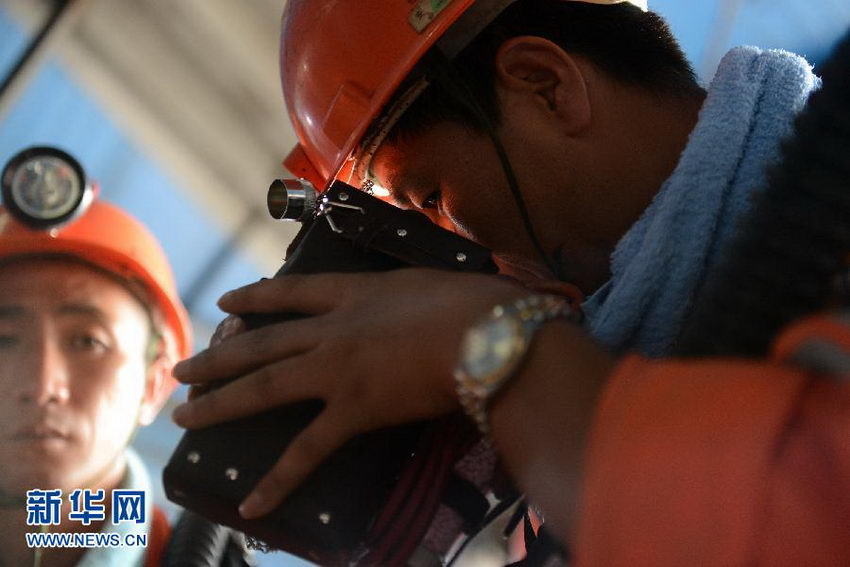 8月19日，矿山救援队队员在下井前查看瓦斯检测仪。