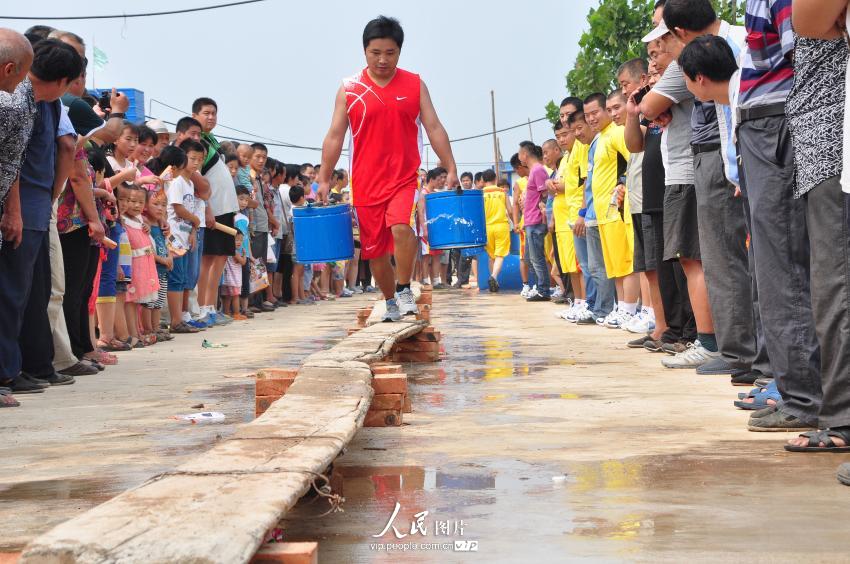 农民运动会项目“提水过独木桥”，要求用时最短且将水桶填满为获胜者。