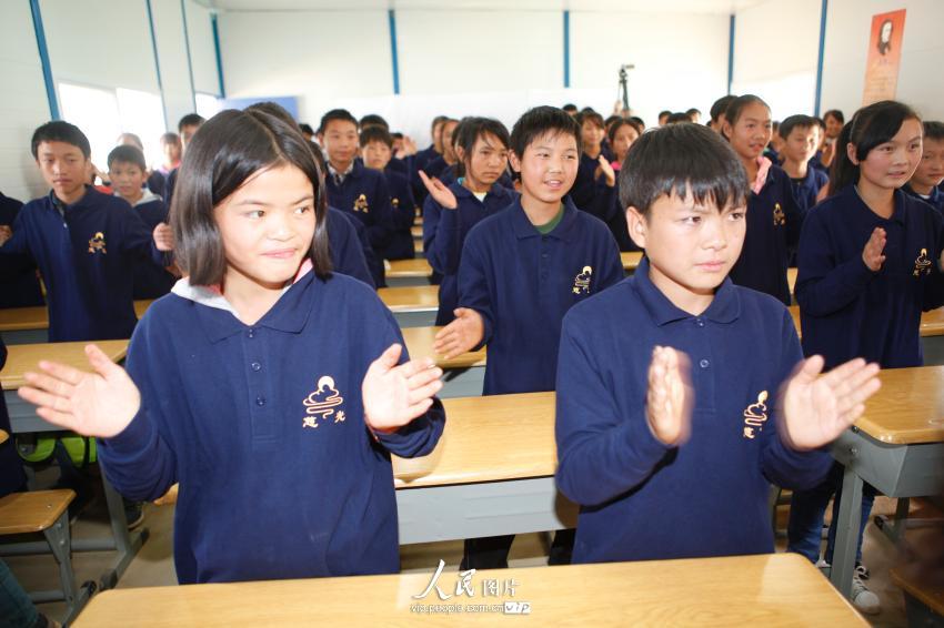 2014年9月1日，在龙泉中学临时活动板房学校的教室内，学生在老师的带领下做游戏。