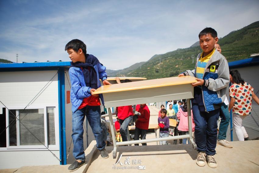 2014年9月1日，两名学生在龙泉中学临时活动板房学校搬课桌。