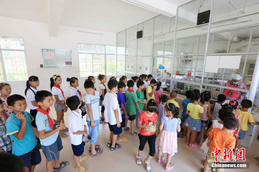 9月1日，学生们在广西柳州市融安县大坡乡岗伟村小学食堂排队领取免费午餐。