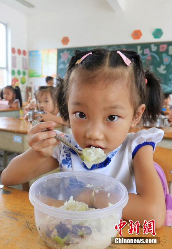 9月1日，一名学生在广西柳州市融安县大坡乡岗伟村小学一年级教室吃免费午餐。