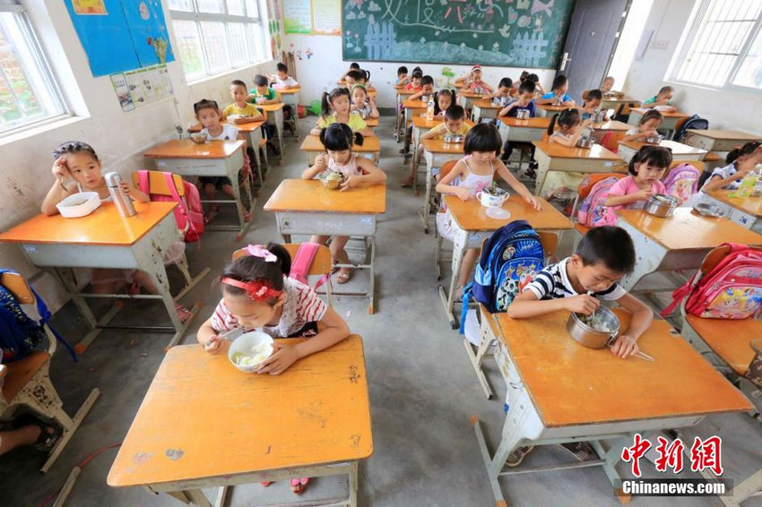9月1日，学生们在广西柳州市融安县大坡乡岗伟村小学一年级教室吃免费午餐。