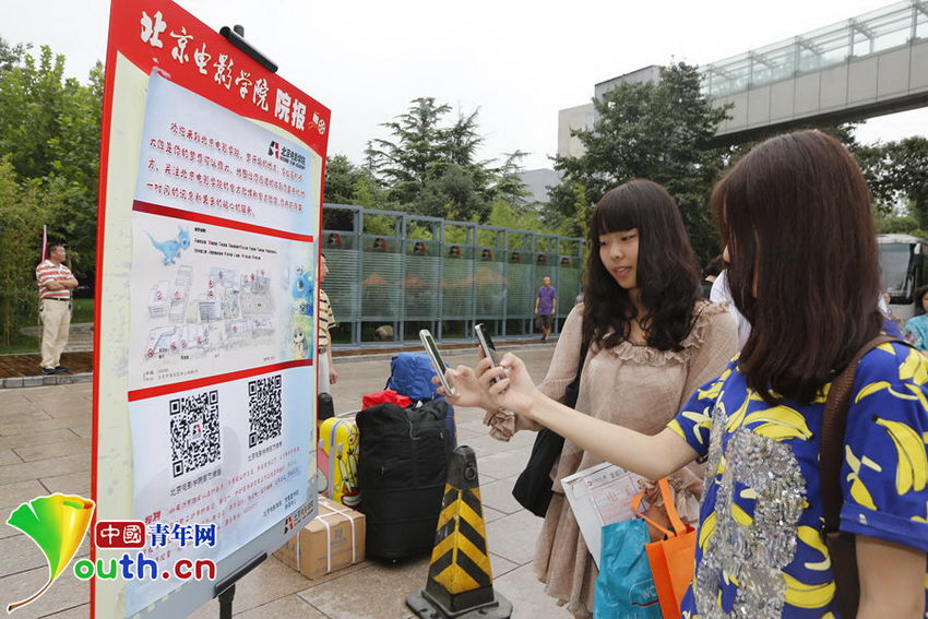 图为学生扫描二维码关注北京电影学院官方微信，以便及时了解招生信息、校园动态、学术活动等信息。