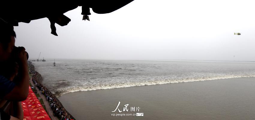 9月8日，来自海内外游客排成人墙在观潮胜地盐官海塘观赏举名闻名的钱塘江海宁“一线潮”。