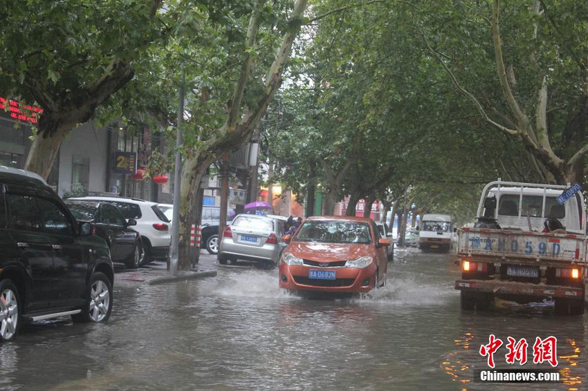 图为郑州郑州市一处积水点，积水久久不散，众多车辆逆水缓慢前行。