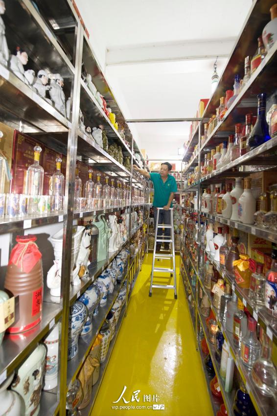 2014年9月18日，陈耿炳收藏的琳琅满目的白酒已把房间挤满，要搬梯子才能整理酒。