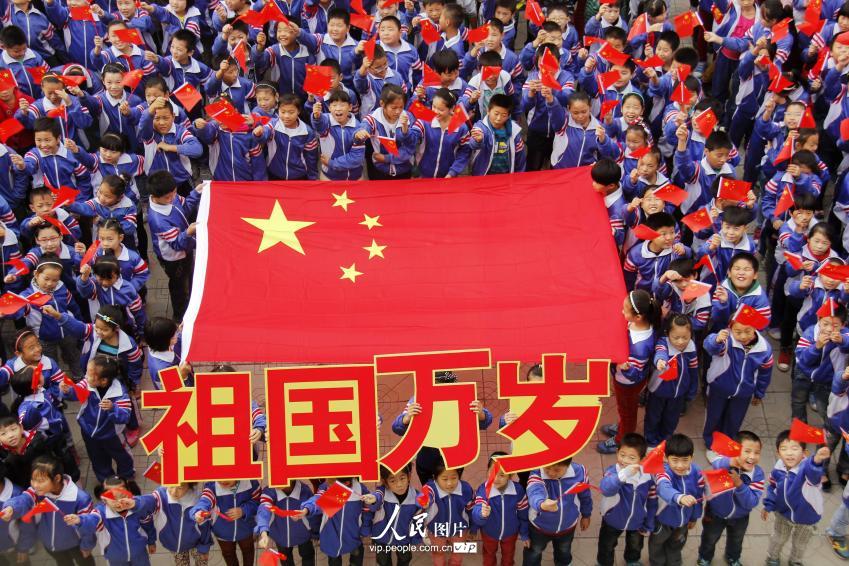 2014年9月30日,河北省广平县明德小学开展“祖国万岁”主题队会活动。学生们通过唱国歌、识国旗、国旗绘画展、诗歌朗诵、手抄报等形式多样的活动,喜迎祖国母亲65周岁生日,为伟大祖国送上最真挚的祝福。(程学虎/人民图片)