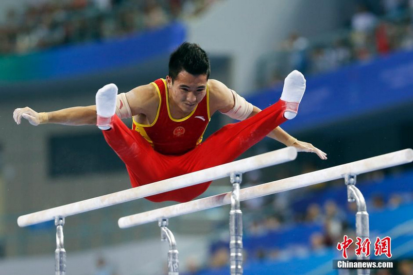 图为中国选手邓书弟在双杠比赛中。