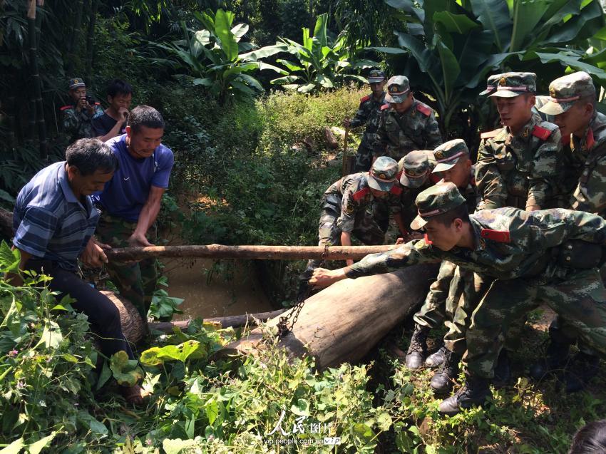 10月8日，武警官兵正在松盘山村帮助村民搬运重物。