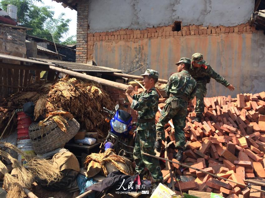 10月8日，武警官兵正在松盘山村拆除倒塌的危棚。