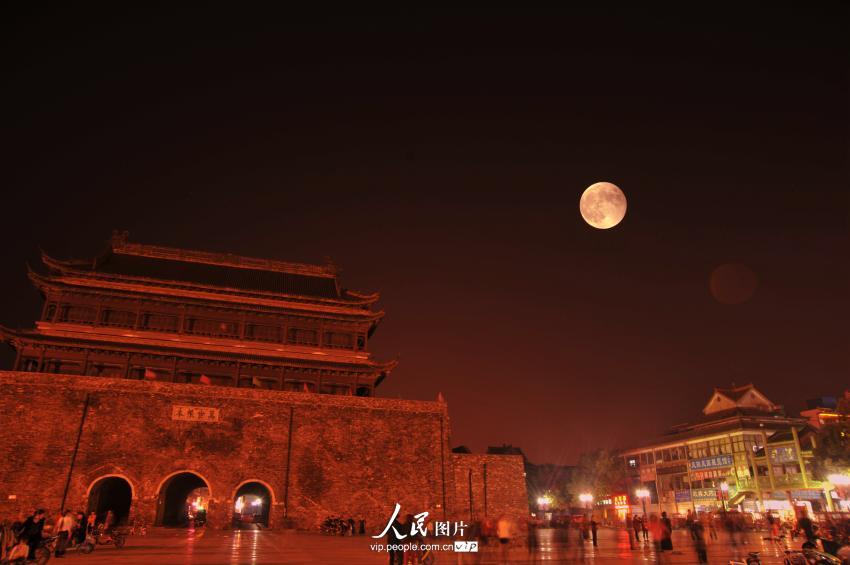 10月8日，安徽省凤阳县，有着600余年历史、被誉为“华夏第一谯楼”的明代鼓楼上空，一轮“红月亮”高挂夜空。（高建业/人民图片）