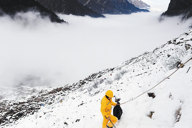12月25日，环卫工人彭万洪在冰川上捡垃圾。