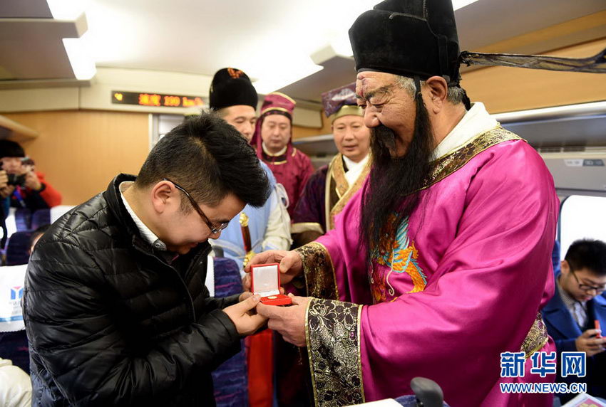 12月28日，开封府包拯的扮演者周学福在郑开城际铁路列车车厢内向乘客赠送纪念品。