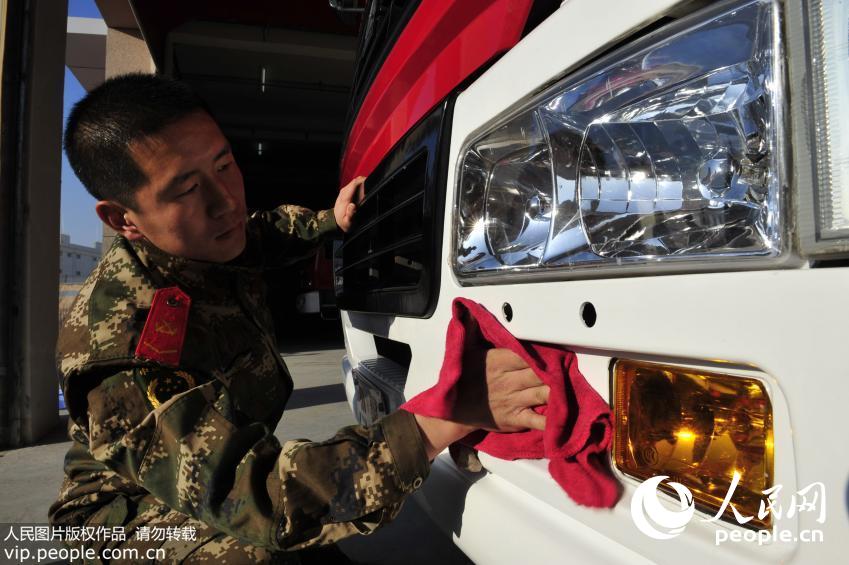 “90后”消防战士白卫红在对消防车进行擦洗。