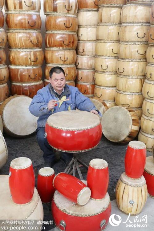 2月6日,河南省孟州市河阳街道办事处缑村“乔家鼓坊”传人乔伯文正在检验成品鼓质量。