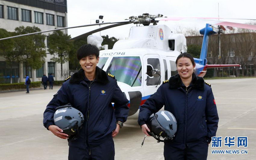 驾机返航后，女搜救直升机机长万秋雯（右）和宋寅在搜救直升机前合影。
