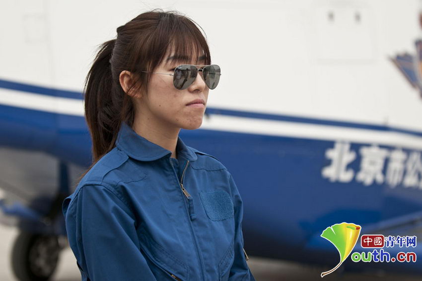 李晗英姿飒爽地站在直升飞机机身前。