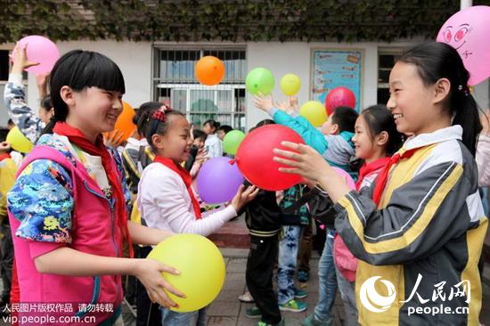学生在利用笑脸气球做传递微笑互动游戏。