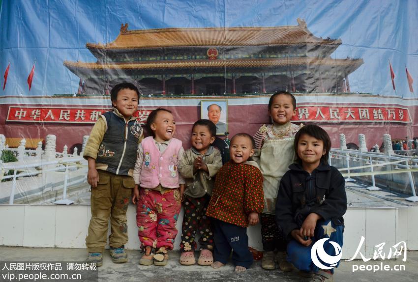 广西省河池市大化县雅龙乡尤齐村小学，大山深处的孩子只有在电视上和课本上看到过北京天安门，当赵明把天安门海报幕布挂起来的时候，快门定格在孩子们灿烂的笑脸上。