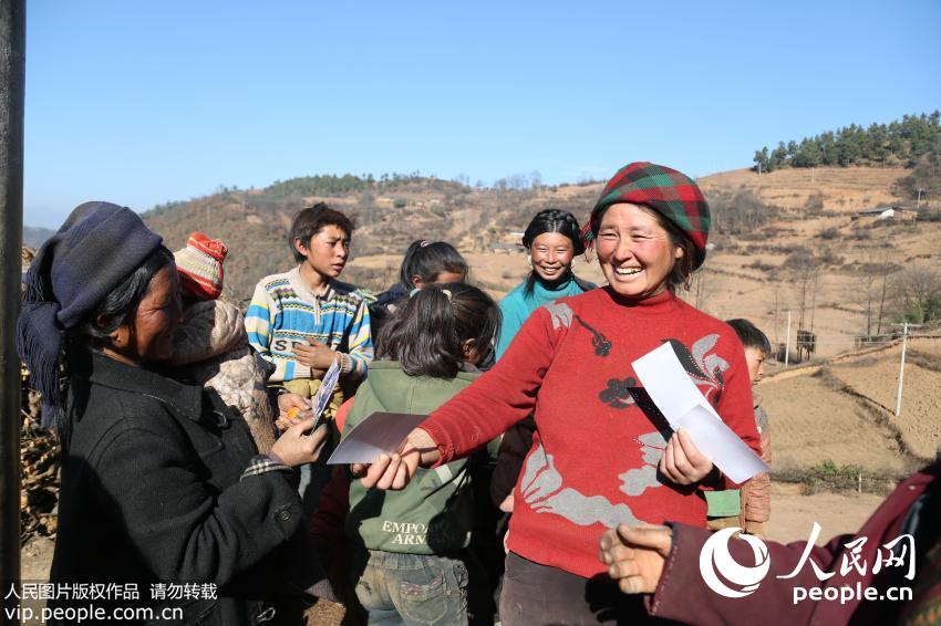 2015年1月3日，四川大凉山美姑县马勒故村，赵明给村民发照片的情景。