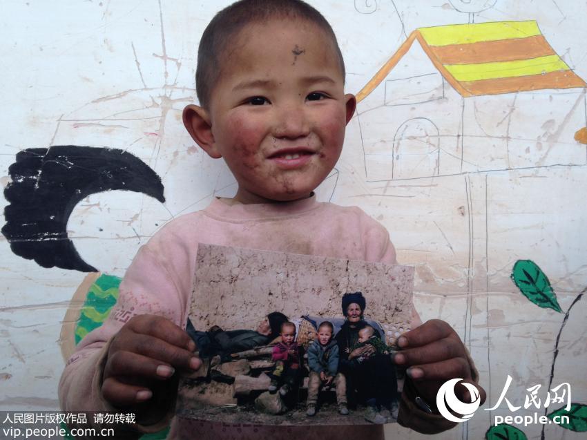 2014年12月24日，四川大凉山，孩子们拿到自己家的照片。