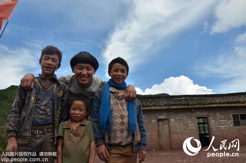 2014年7月2日，四川大凉山，赵明和孩子们在学校操场前的合影。