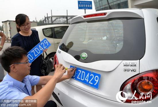 8月19日，河北省邯郸市车管所民警正在为纯电动汽车车主挂牌照。