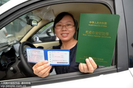 8月19日，河北省邯郸市一市民展示纯电动汽车办理车牌的相关手续。