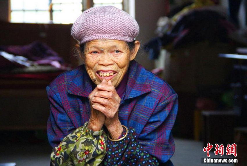 12月3日，在广西柳江县土博镇二中，一名陪读奶奶坐在房门口。