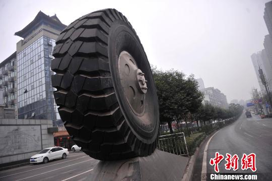 图为公路中间摆放了巨型轮胎。