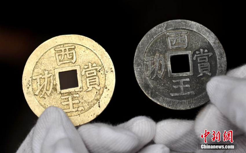 1月5日，工作人员展示“江口沉银遗址”发现的“西王赏功”金、银币。