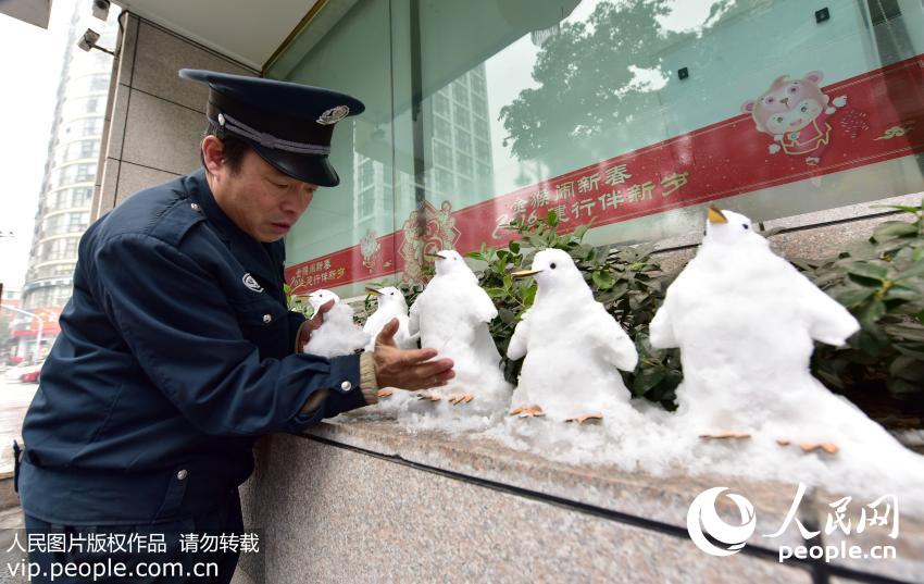 杭州“雪雕保安”妙手捏出21只“企鹅”