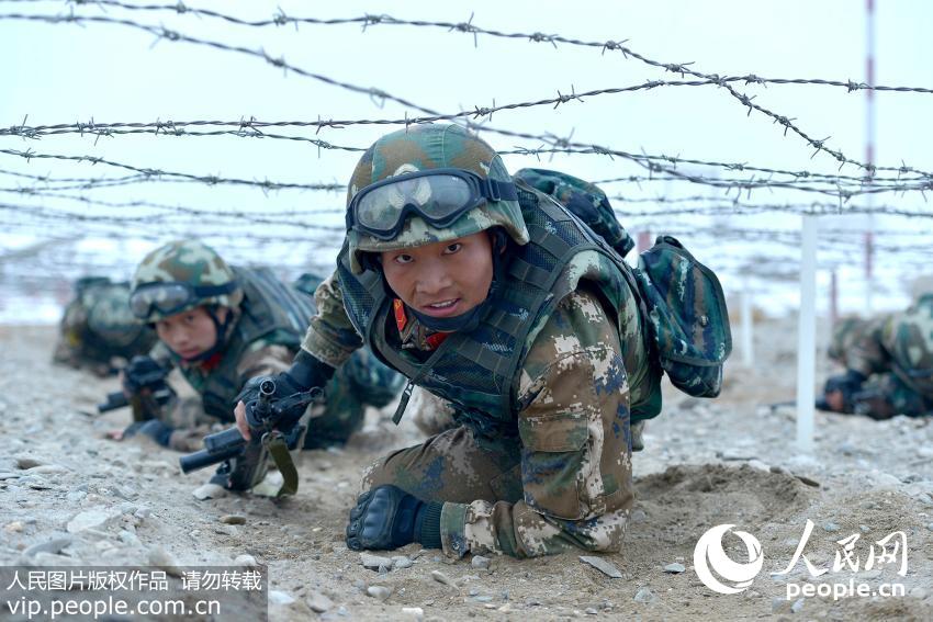 武警特战队员利用战术动作通过地桩网。 