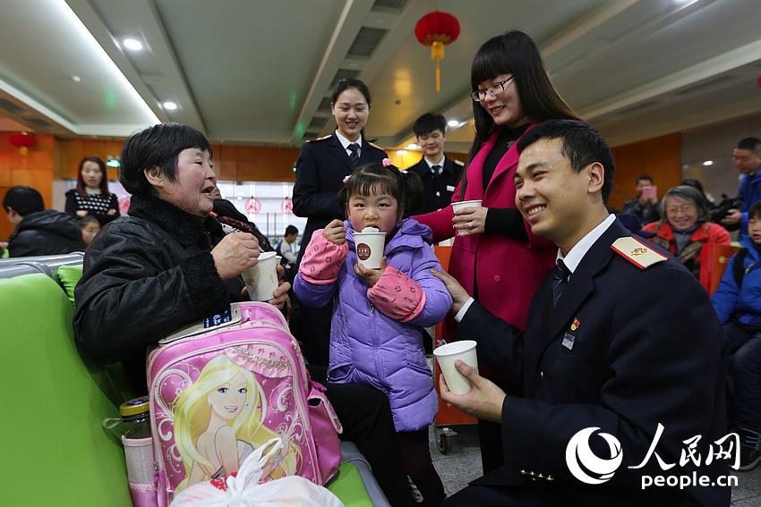2016年2月22日，元宵佳节，上海火车站工作人员刘志慧（右一）携新婚妻子杨娇（右二）为广大旅客送上爱心汤圆。王初 摄
