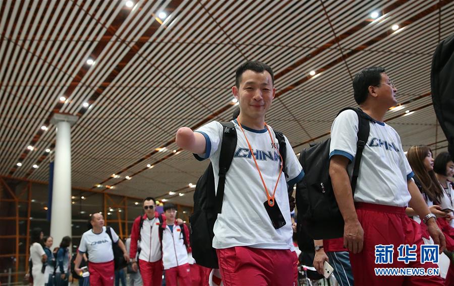 8月30日，游泳运动员许庆（前左）在机场准备出发。