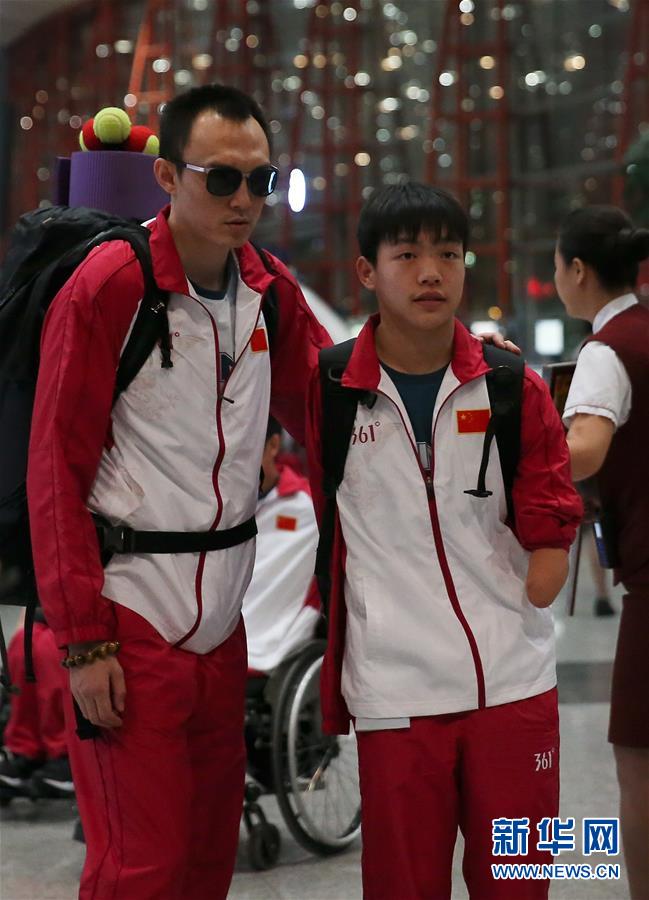8月30日，游泳运动员杨博尊（左）与队友在机场等待出发。