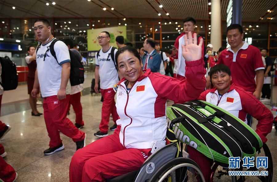 8月30日，轮椅网球运动员董福利（中）在机场准备出发。