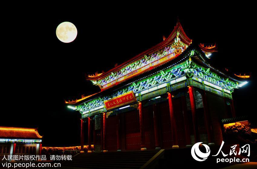 11月14日晚，“超级月亮”现身新疆巴里坤上空，与古建筑、古城墙互映成景，美轮美奂。（吴红军/人民图片）