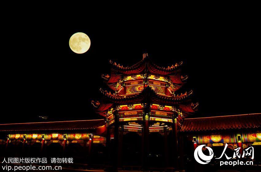 11月14日晚，“超级月亮”现身新疆巴里坤上空，与古建筑、古城墙互映成景，美轮美奂。（吴红军/人民图片）