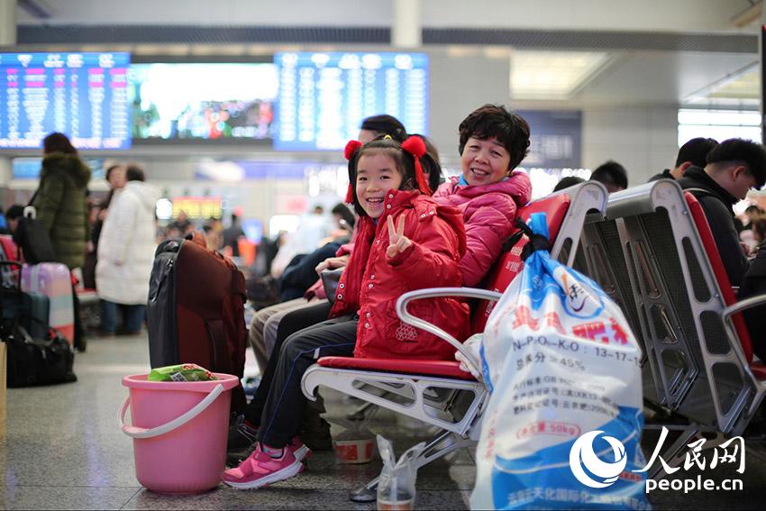 1月13日，上海虹桥火车站候车室内，6岁的小旅客扬扬和她的外婆正在候车。（王初/摄）