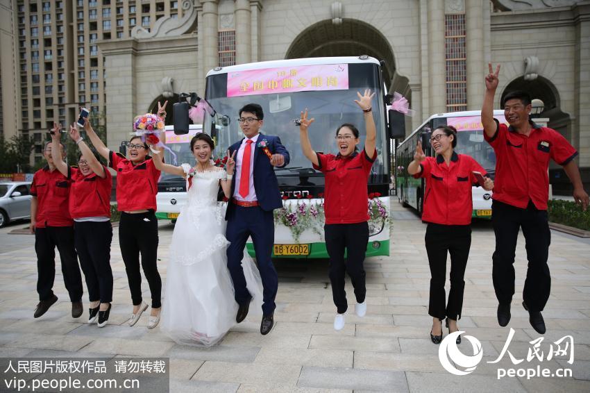 7月9日，新郎新娘在自己驾驶的公交车前欢快地跳了起来。