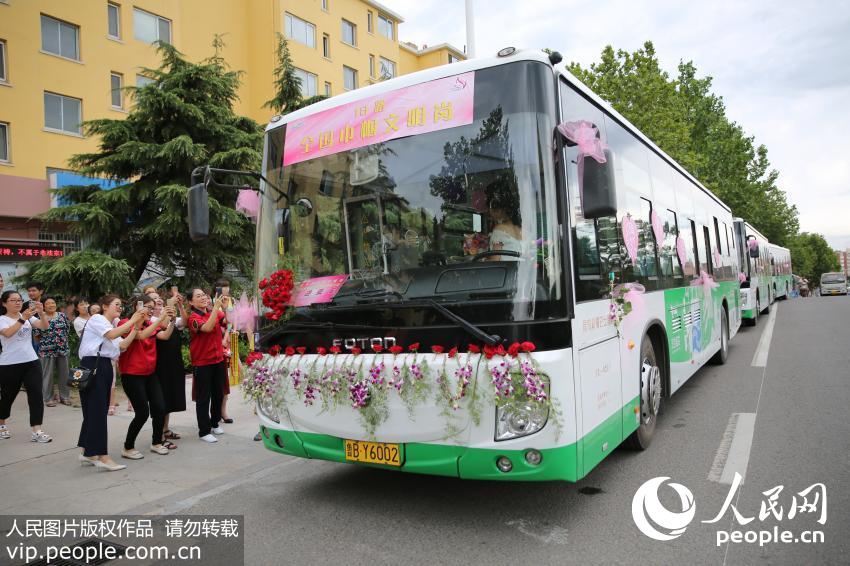 7月9日，看到公交婚车，路人纷纷举起了手机拍照。