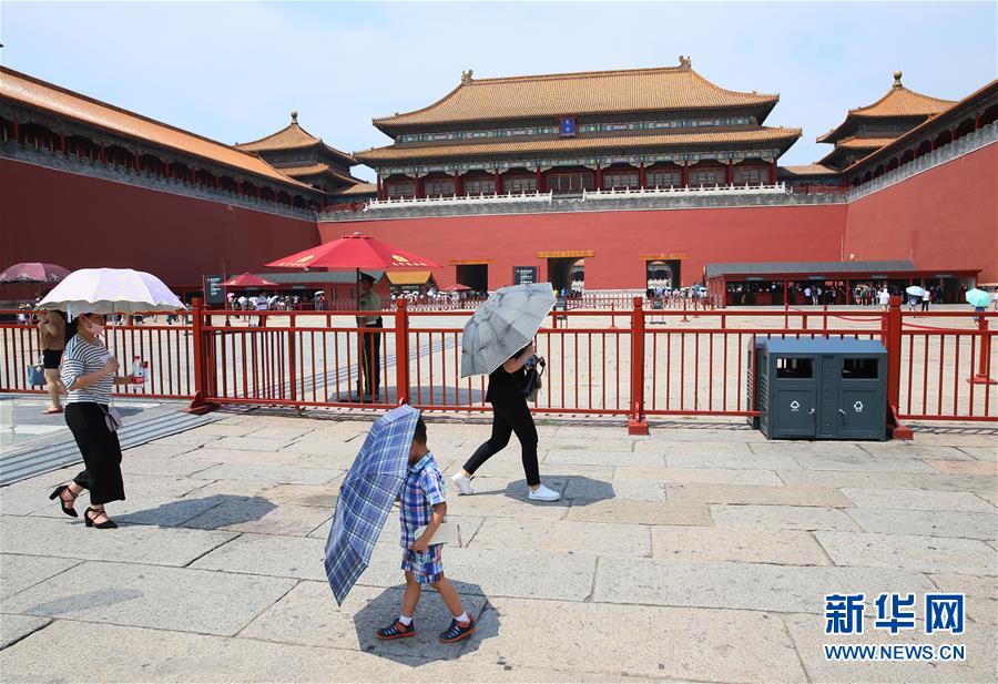 7月12日，游客顶着高温打伞在北京故宫游玩。（才扬）