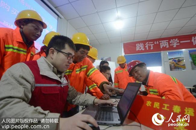 扬州:春运火车票开售 志愿者为农民工网购火车