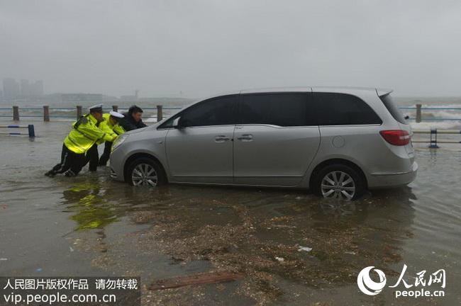 青岛:台风掀巨浪汽车被淹 交警海水中冒险推车
