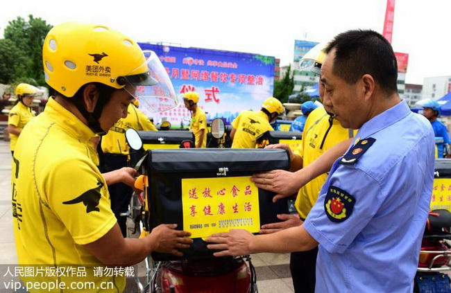 9月10日，陕西省城固县市场监督管理局的工作人员在给“美团”工作车上张贴食品安全宣传标语。